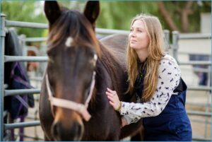 Learn more about the Melbourne DVM woman standing next to horse