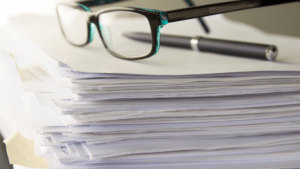 stack of paperwork with glasses