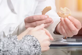 audiologist holding hearing aid
