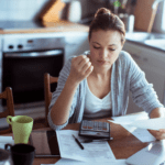 woman at table looking at bills