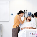 medical students examining a patient lying in hospital bed