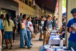 university students during open day standing in front of tables